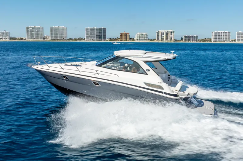 "plymouth Breeze" Yacht Photos Pics 2020 Regal 35 Sport Coupe cruising on blue ocean with city skyline backdrop.