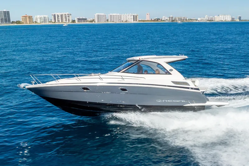 "plymouth Breeze" Yacht Photos Pics 2020 Regal 35 Sport Coupe cruising on blue ocean near city skyline.