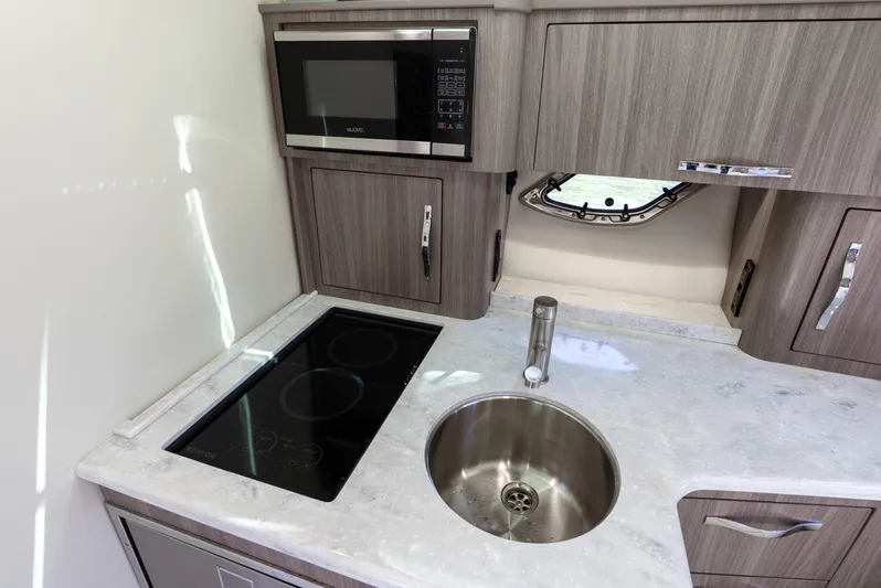 "plymouth Breeze" Yacht Photos Pics 2020 Regal 35 Sport Coupe kitchen with microwave, stovetop, and sink.