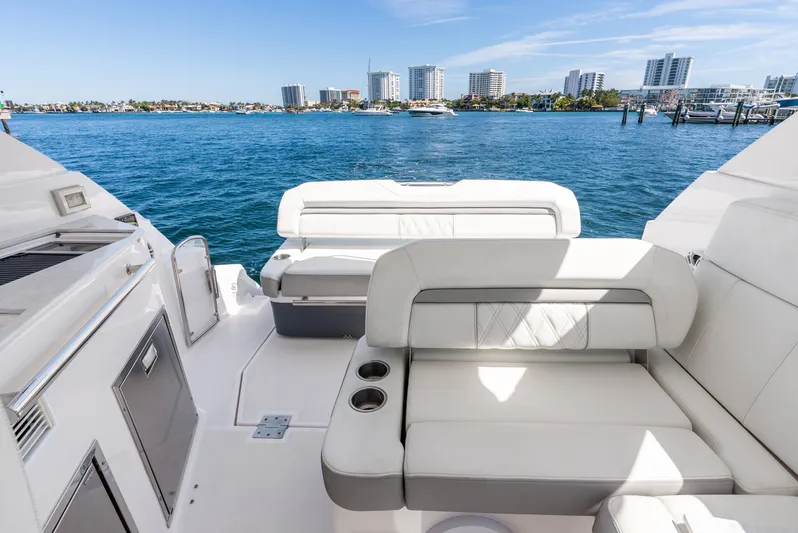 "plymouth Breeze" Yacht Photos Pics 2020 Regal 35 Sport Coupe yacht interior with white seating, overlooking a coastal cityscape.