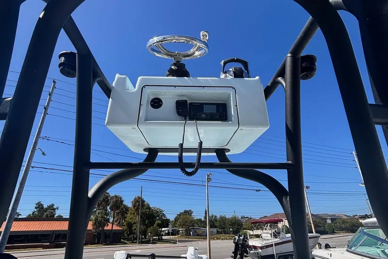  Yacht Photos Pics 2021 Yellowfin 26 Hybrid boat console with steering wheel and controls, under clear blue sky.