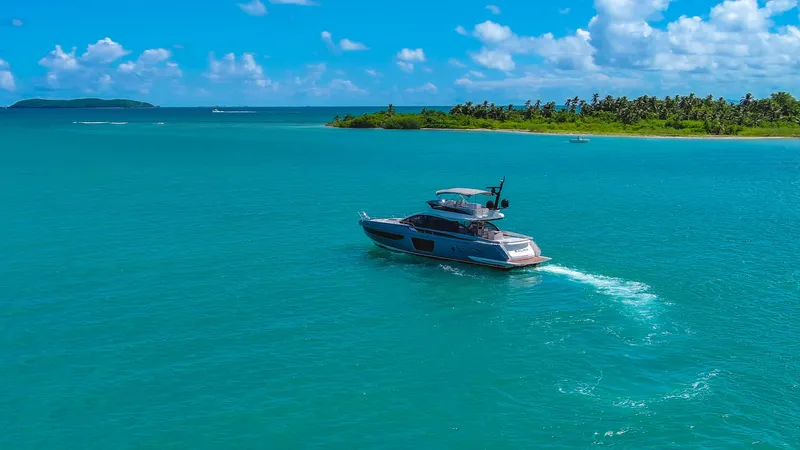Salina Yacht Photos Pics 2024 Azimut S7 yacht cruising in turquoise waters near a lush, tropical island.