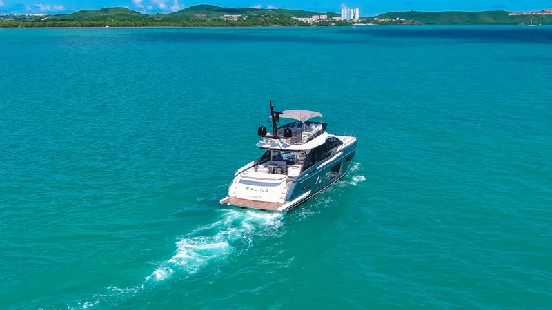 Salina Yacht Photos Pics 2024 Azimut S7 yacht cruising on turquoise waters with scenic coastal backdrop.