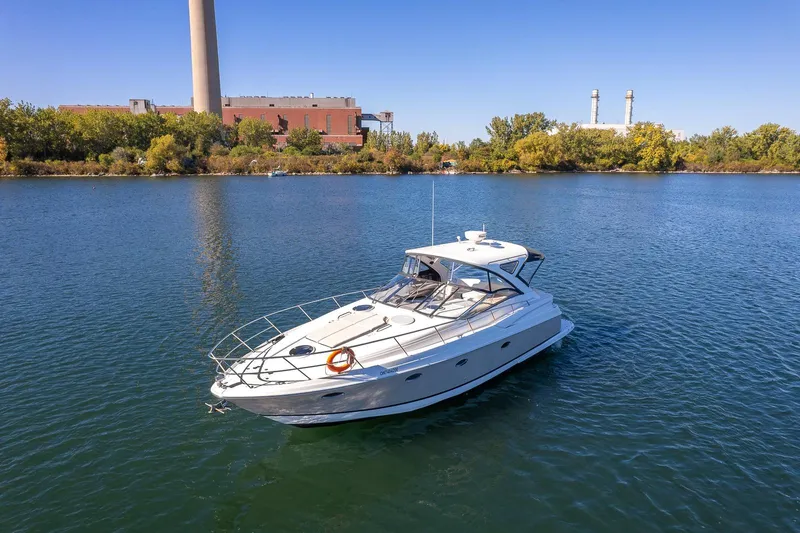  Yacht Photos Pics 2009 Regal Commodore 4060 yacht on a serene lake with industrial backdrop.