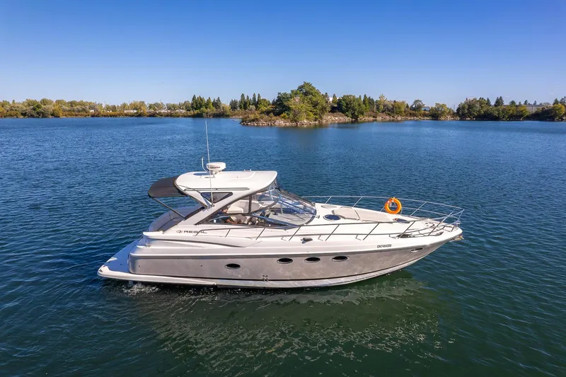  Yacht Photos Pics 2009 Regal Commodore 4060 yacht cruising on a serene lake under a clear blue sky.