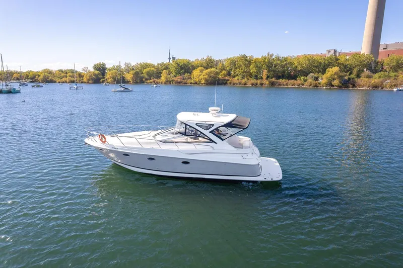  Yacht Photos Pics 2009 Regal Commodore 4060 yacht cruising on a serene lake with lush green shoreline.