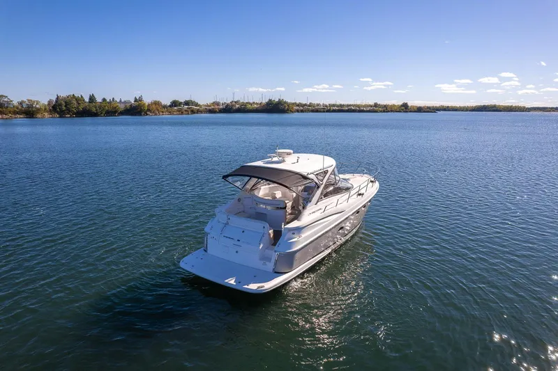  Yacht Photos Pics 2009 Regal Commodore 4060 yacht cruising on a serene lake under clear blue skies.
