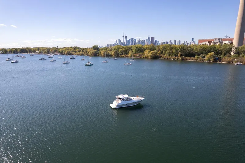  Yacht Photos Pics 2009 Regal Commodore 4060 yacht on serene lake with city skyline backdrop.