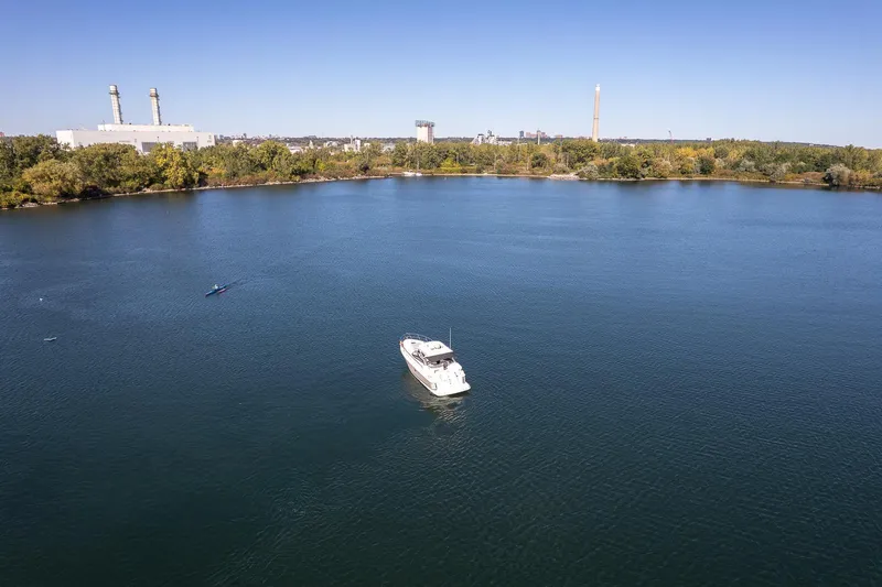  Yacht Photos Pics 2009 Regal Commodore 4060 yacht on a serene lake with industrial backdrop.