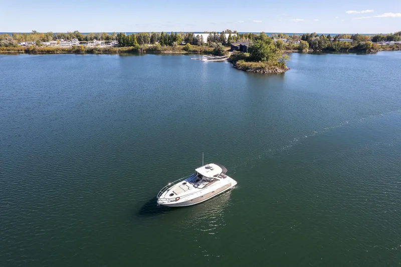  Yacht Photos Pics 2009 Regal Commodore 4060 yacht cruising on a serene lake near a small island.