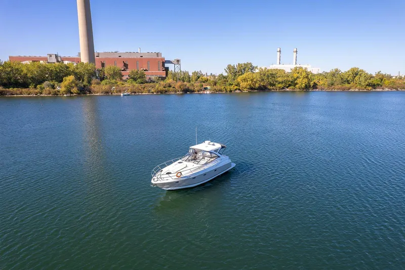  Yacht Photos Pics A 2009 Regal Commodore 4060 yacht on a calm river near industrial buildings.