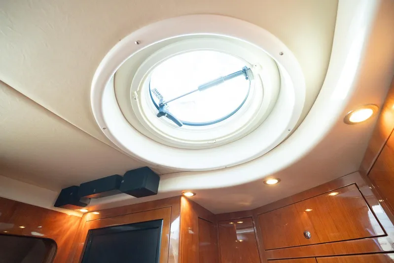  Yacht Photos Pics Interior of 2009 Regal Commodore 4060 yacht with circular skylight and wooden paneling.