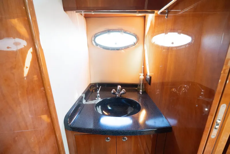  Yacht Photos Pics Luxurious bathroom in 2009 Regal Commodore 4060 yacht with sleek black sink and wooden cabinetry.