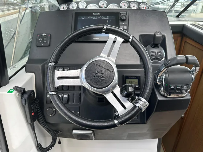 Andalucia Yacht Photos Pics Steering wheel and controls of a 2017 Jeanneau NC 11 boat cockpit.