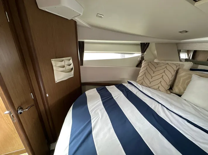 Andalucia Yacht Photos Pics Interior cabin of 2017 Jeanneau NC 11 with striped bedding and decorative pillows.
