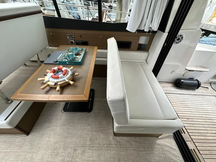 Andalucia Yacht Photos Pics Interior of 2017 Jeanneau NC 11 yacht with elegant seating and wooden table.