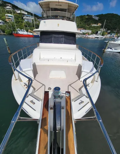 'elixir' Yacht Photos Pics 1982 Hatteras 56 Wide Body yacht docked in a scenic marina.