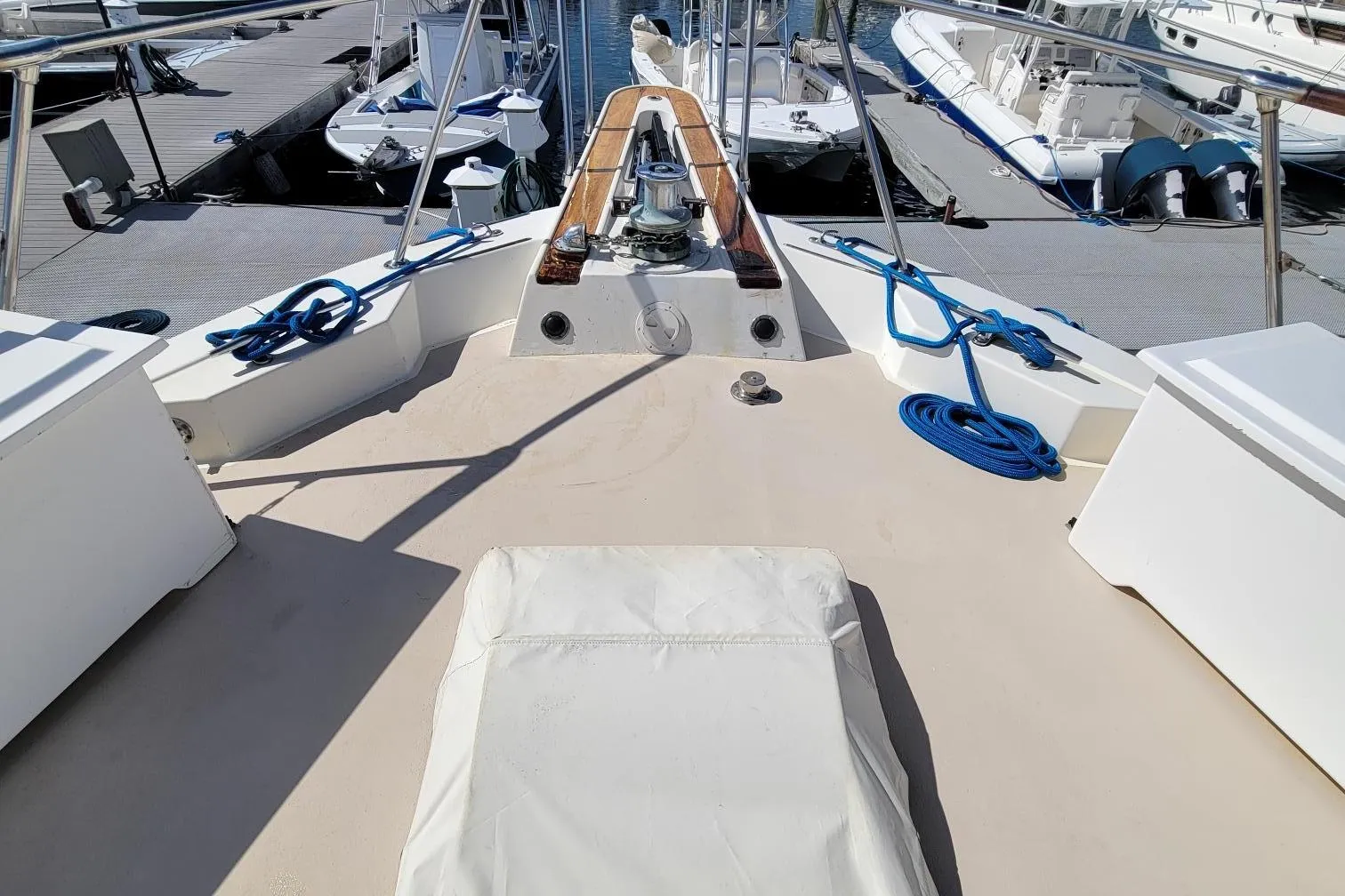 1982 Hatteras 56 Wide Body yacht deck with mooring ropes and docked boats.