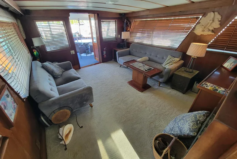 'elixir' Yacht Photos Pics Interior of 1982 Hatteras 56 Wide Body yacht with cozy seating and wooden accents.