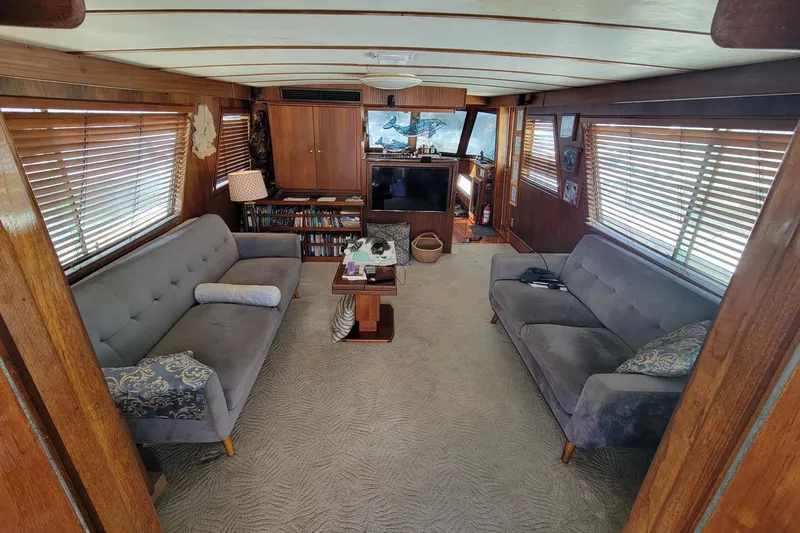 'elixir' Yacht Photos Pics Interior of 1982 Hatteras 56 Wide Body yacht with cozy seating and wooden accents.