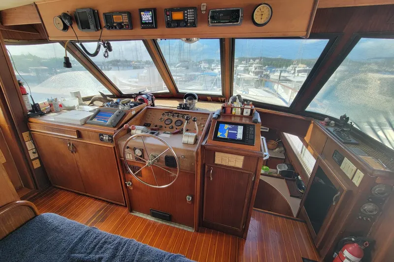 'elixir' Yacht Photos Pics 1982 Hatteras 56 Wide Body yacht helm with wooden interior and navigation equipment.