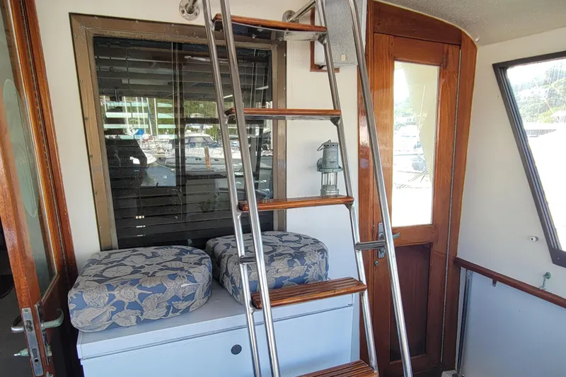 'elixir' Yacht Photos Pics Interior of 1982 Hatteras 56 Wide Body yacht with ladder and cushioned seating.
