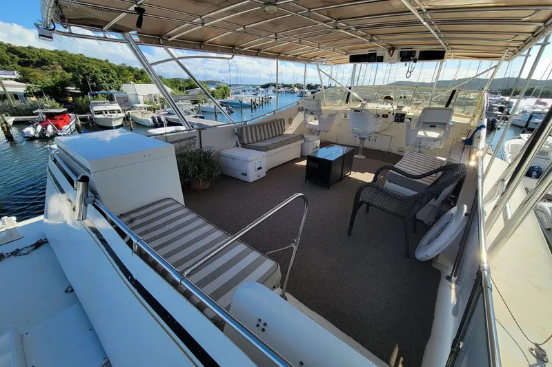 'elixir' Yacht Photos Pics Luxurious 1982 Hatteras 56 Wide Body yacht with spacious deck and scenic marina view.