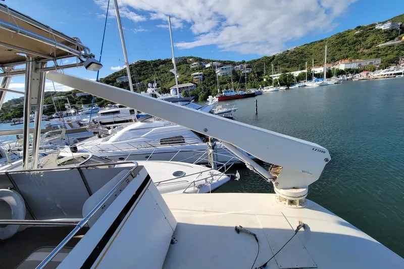 'elixir' Yacht Photos Pics 1982 Hatteras 56 Wide Body yacht docked in a scenic marina with surrounding hills.