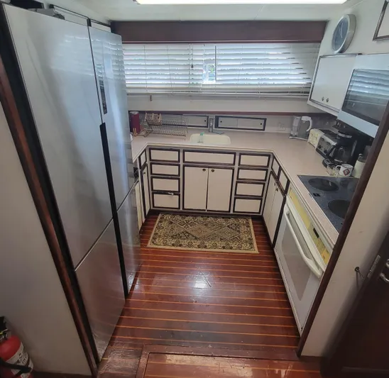 'elixir' Yacht Photos Pics 1982 Hatteras 56 Wide Body yacht kitchen with wood flooring and modern appliances.