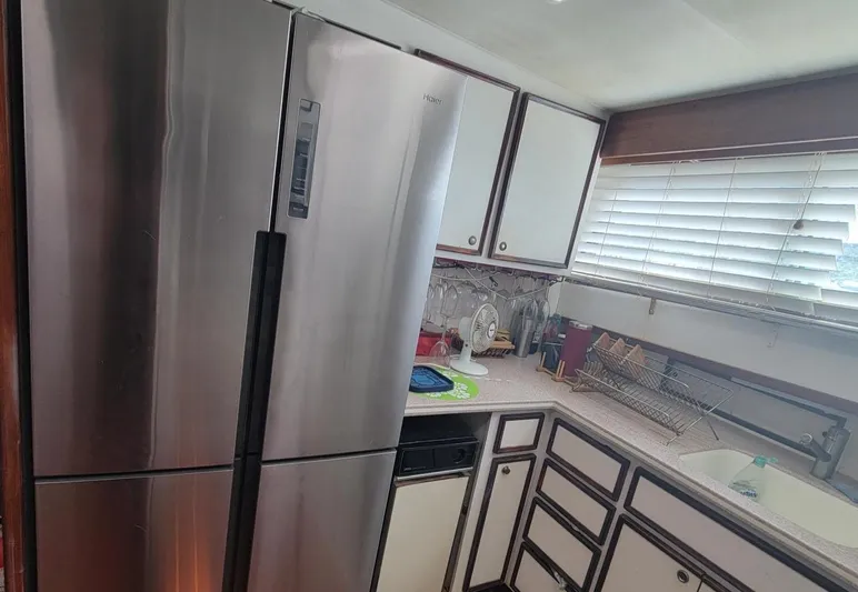 'elixir' Yacht Photos Pics Modern kitchen inside a 1982 Hatteras 56 Wide Body yacht with stainless steel appliances.