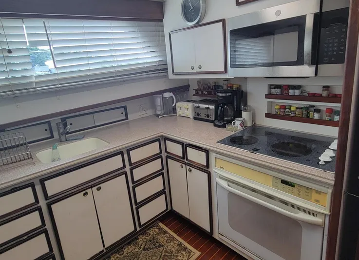 'elixir' Yacht Photos Pics Kitchen interior of 1982 Hatteras 56 Wide Body yacht with modern appliances and cabinetry.