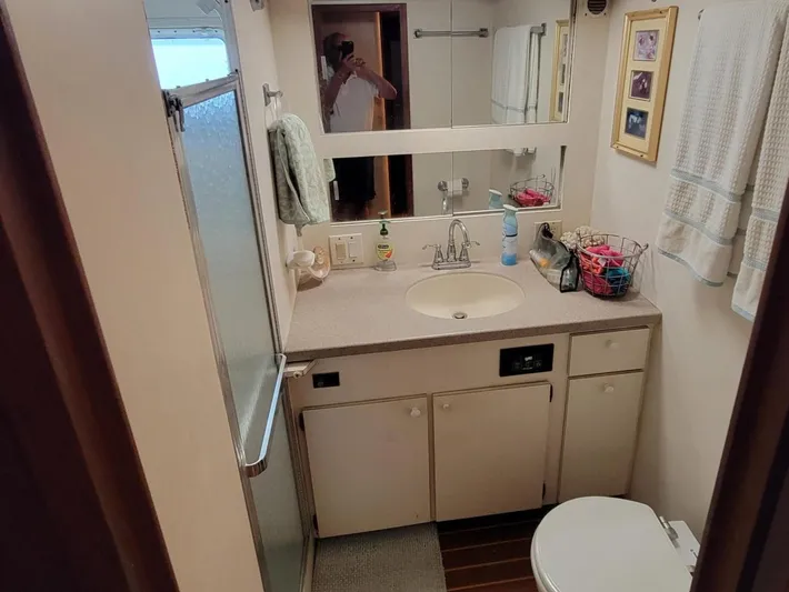 'elixir' Yacht Photos Pics 1982 Hatteras 56 Wide Body yacht bathroom with shower, sink, and storage cabinets.