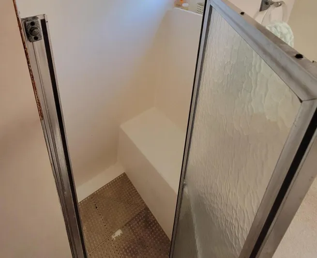 'elixir' Yacht Photos Pics Shower area inside 1982 Hatteras 56 Wide Body yacht, featuring glass door and white interior.