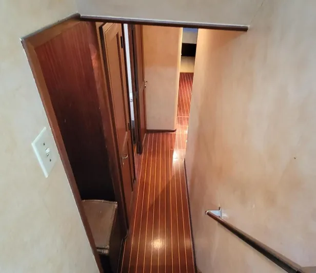 'elixir' Yacht Photos Pics Interior view of 1982 Hatteras 56 Wide Body yacht, featuring wooden flooring and hallway.