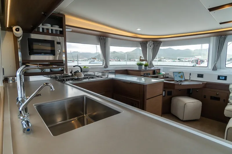 Altitude Adjustment Yacht Photos Pics Modern kitchen interior of 2022 Lagoon 46 catamaran with scenic window views.