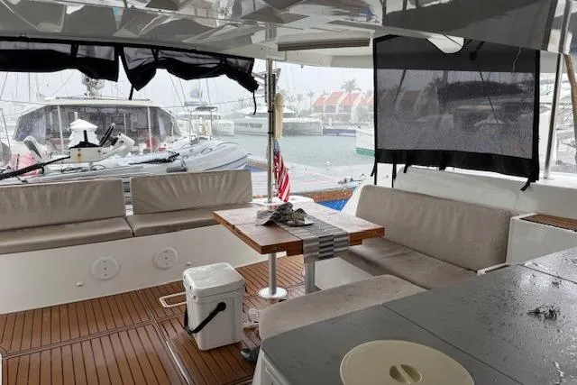 Altitude Adjustment Yacht Photos Pics 2022 Lagoon 46 yacht interior with seating, table, and marina view.