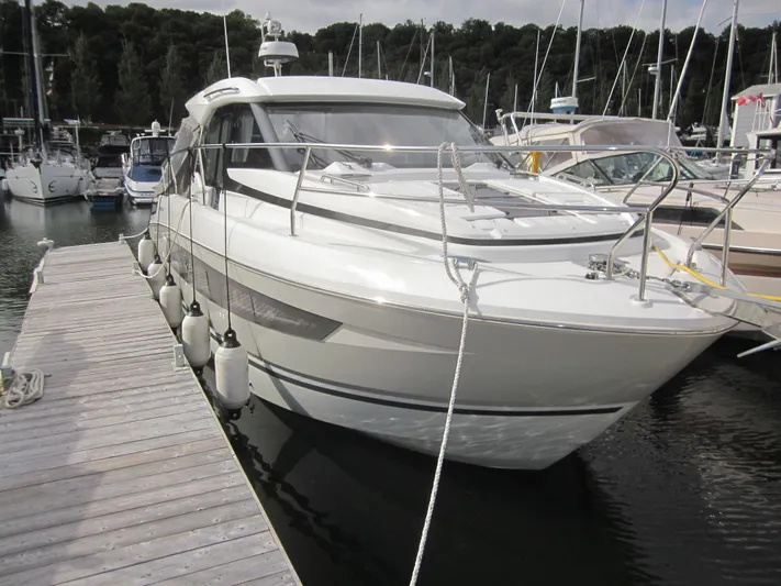  Yacht Photos Pics 2019 Jeanneau NC 33 docked at marina, surrounded by other boats.