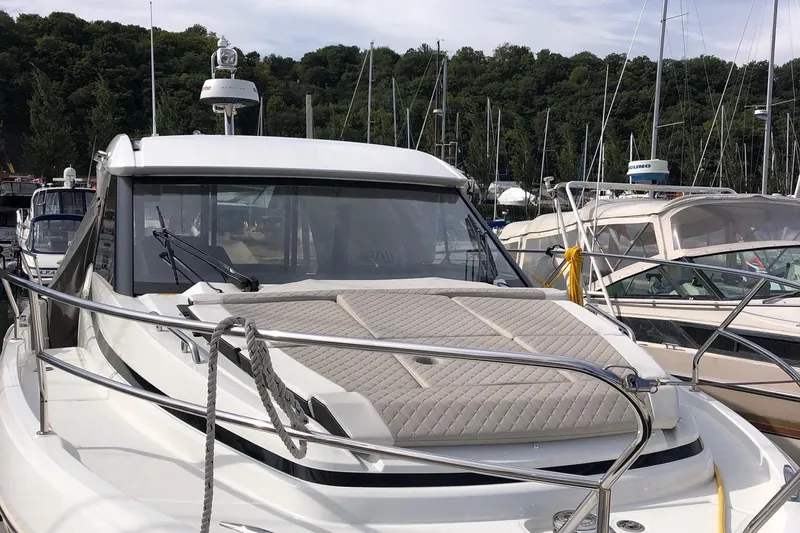  Yacht Photos Pics 2019 Jeanneau NC 33 yacht docked at marina with lush green backdrop.