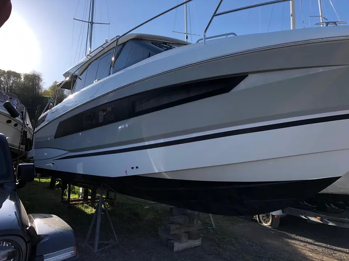  Yacht Photos Pics 2019 Jeanneau NC 33 boat on stands, side view, outdoors.