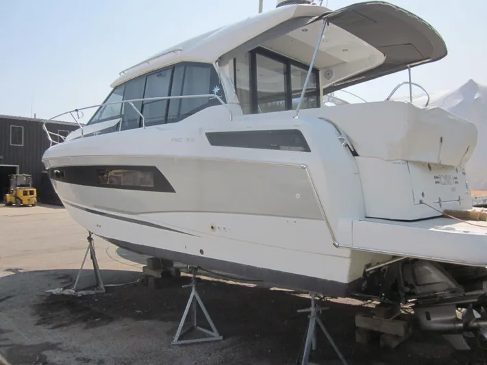  Yacht Photos Pics 2019 Jeanneau NC 33 boat on stands, side view, in a marina setting.