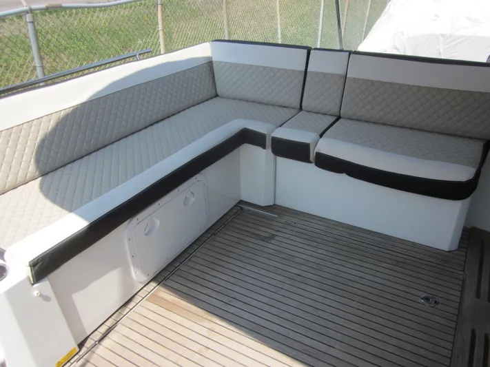  Yacht Photos Pics 2019 Jeanneau NC 33 boat interior with cushioned seating and wooden flooring.