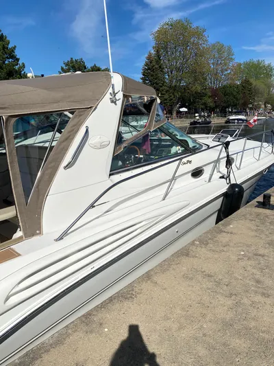  Yacht Photos Pics 1998 Sea Ray 400 Sundancer docked, featuring sleek design and beige canopy under clear blue sky.