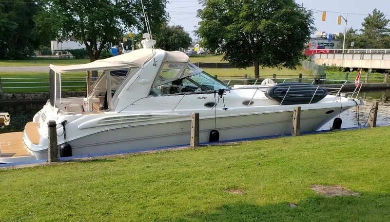  Yacht Photos Pics 1998 Sea Ray 400 Sundancer yacht docked by a grassy area, under clear skies.
