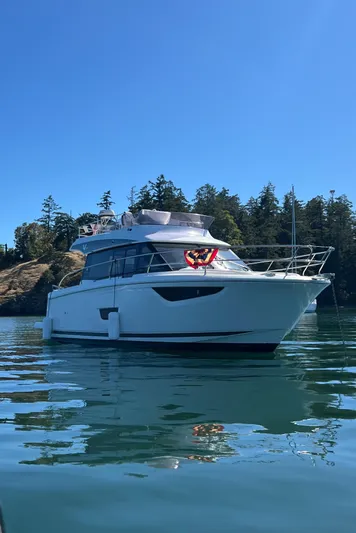  Yacht Photos Pics 2019 Jeanneau Velasco 37F yacht on serene water with forested background.