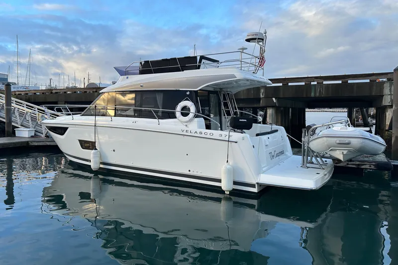  Yacht Photos Pics 2019 Jeanneau Velasco 37F yacht docked at marina, reflecting on calm water.