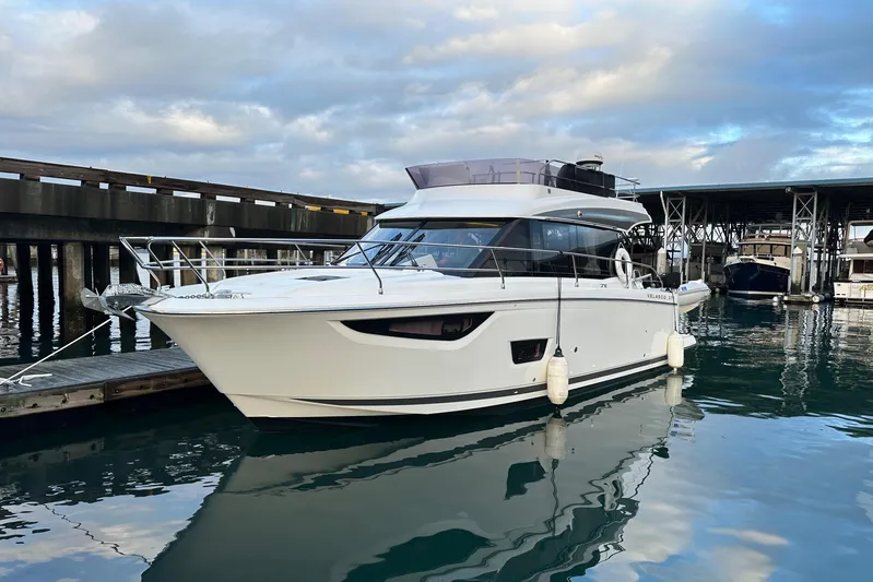  Yacht Photos Pics 2019 Jeanneau Velasco 37F yacht docked in marina, reflecting on calm water.
