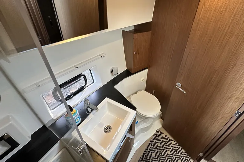  Yacht Photos Pics 2019 Jeanneau Velasco 37F bathroom with sink, toilet, and wooden cabinetry.