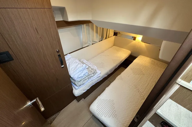  Yacht Photos Pics Cabin interior of 2019 Jeanneau Velasco 37F with twin beds and cozy lighting.