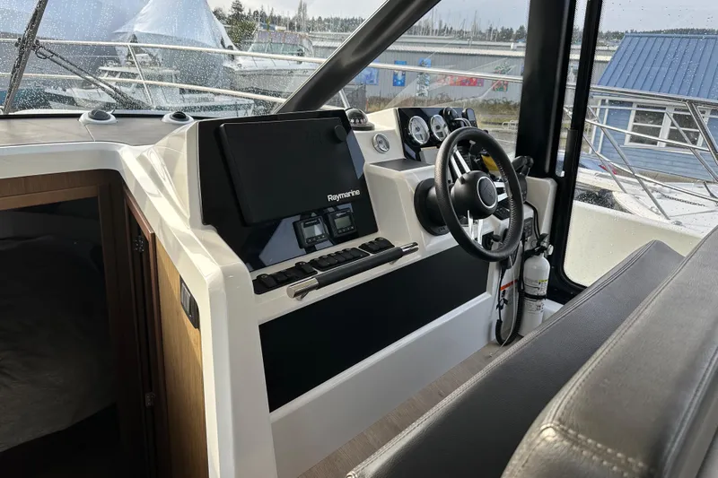  Yacht Photos Pics 2019 Jeanneau Velasco 37F helm with modern navigation equipment and steering wheel.