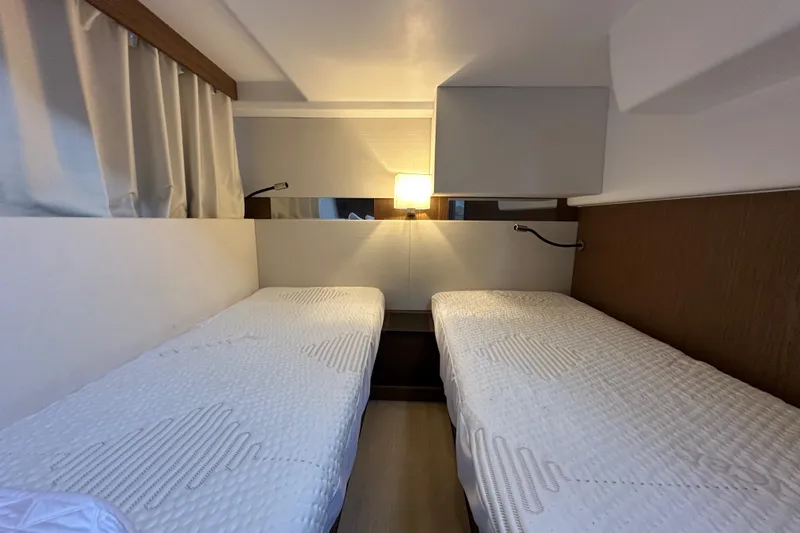  Yacht Photos Pics Twin cabin interior of 2019 Jeanneau Velasco 37F yacht, featuring cozy beds and ambient lighting.